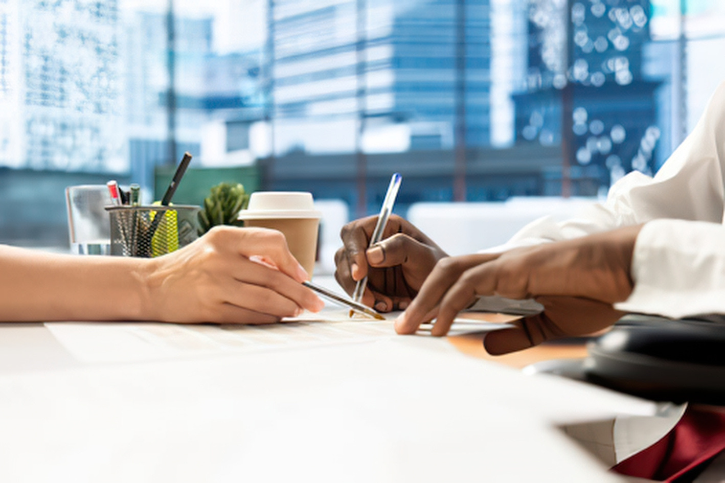 Two professionals reviewing and signing a partnership document
